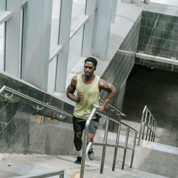 Man performing a controlled strength exercise in a modern gym.